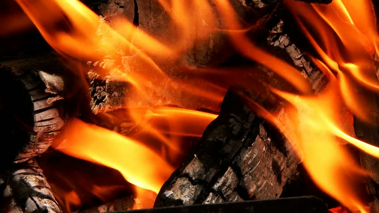 Brennendes Kaminfeuer mit lodernden Flammen und Holzscheiten